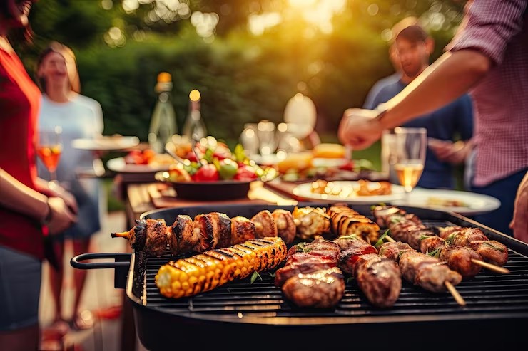 Smoked meats and grilled corn on a backyard barbecue